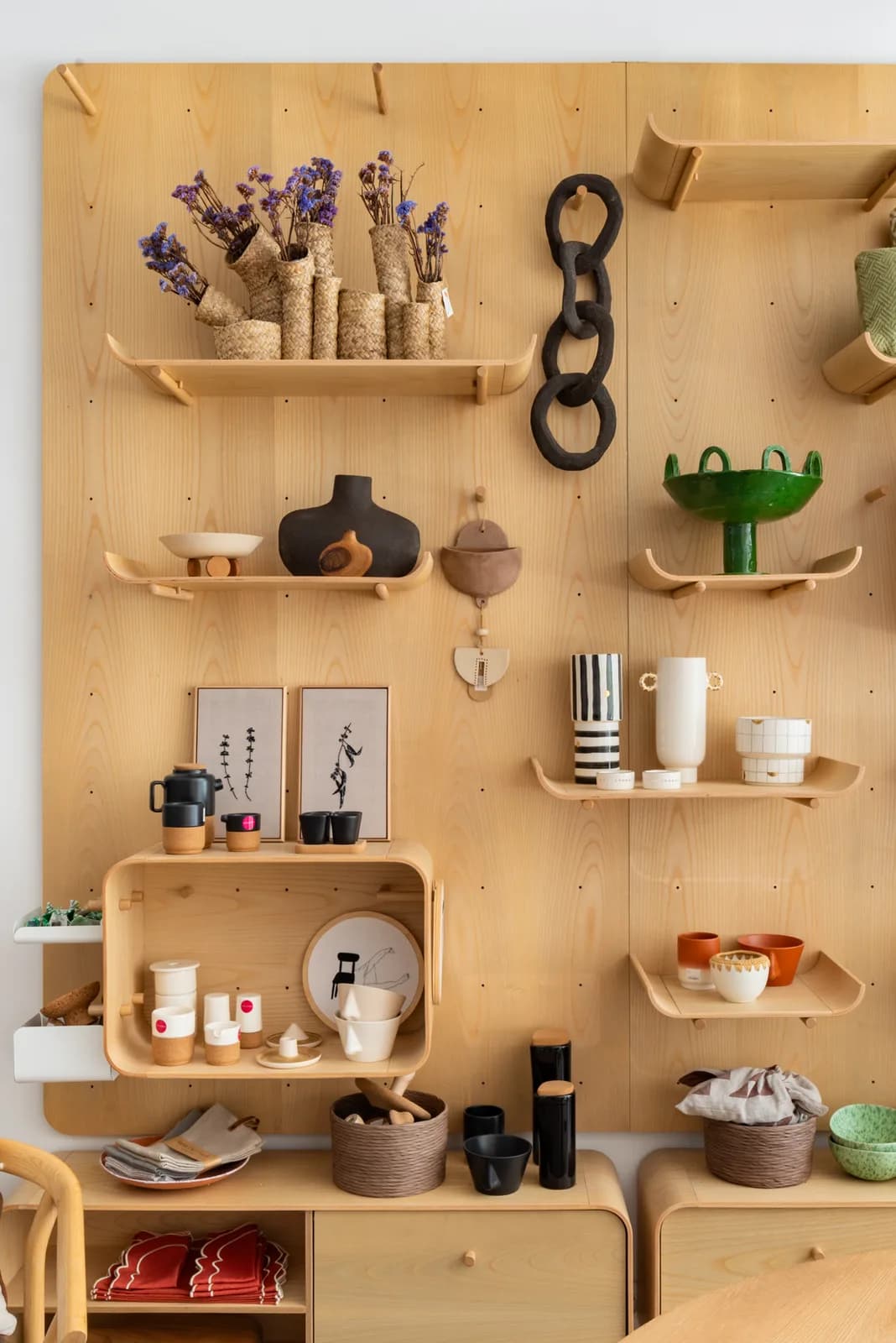 A plywood display wall of Portuguese ceramics and baskets at Santo Infante